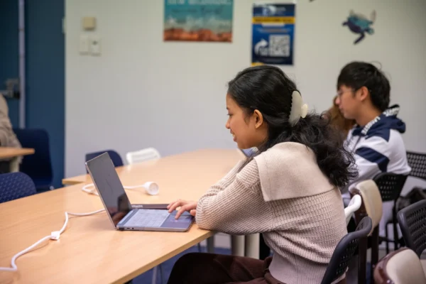 a student is learing on his laptop in her class